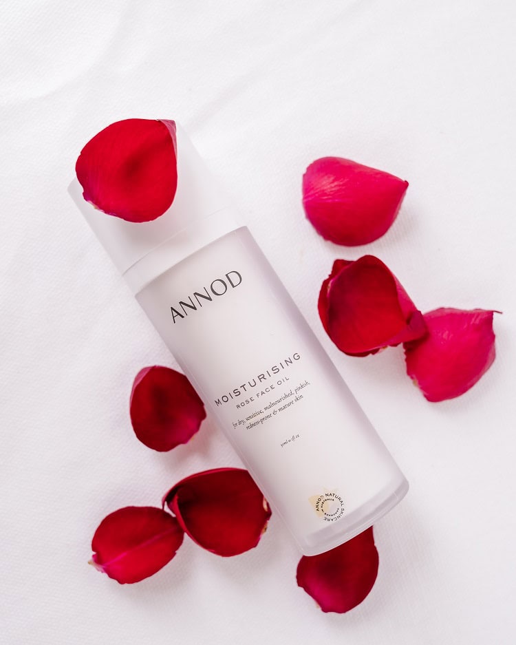 A bottle Annod's Moisturising Rose Face Oil with rose petals